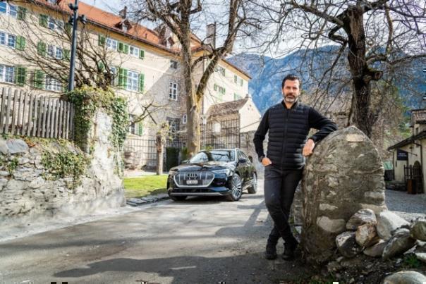 Andreas Caminada mit seinem neuen Audi e-tron vor dem Schloss Schauenstein (Foto: Thomas Buchwalder)